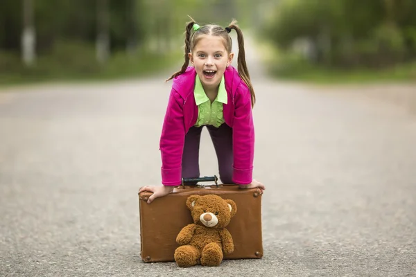 Klein meisje met een koffer — Stockfoto