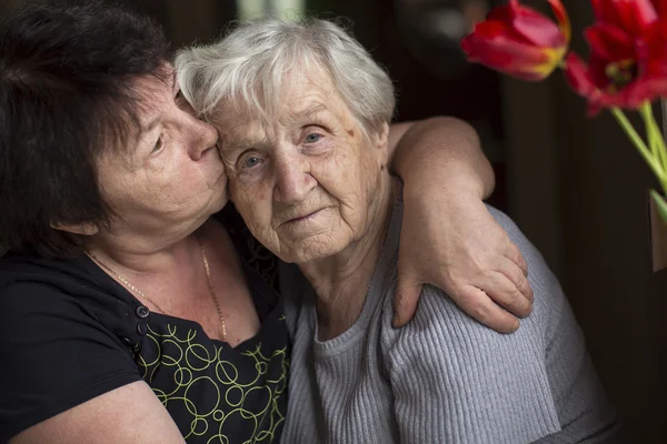 Женщина целует свою старую мать — стоковое фото