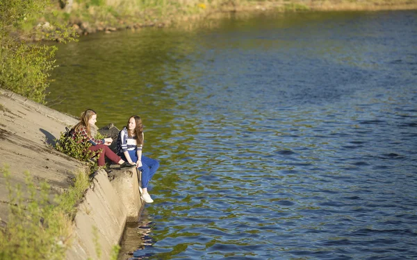 Tiener meisjes zitten op een pier — Stockfoto