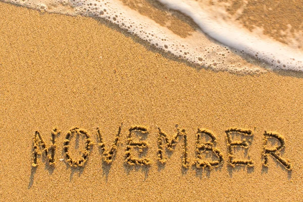 Palabra noviembre en la arena — Foto de Stock