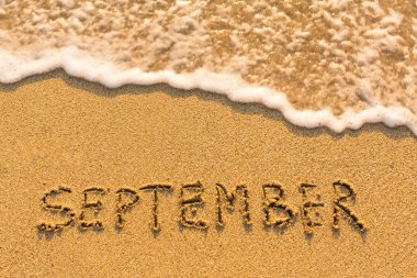 September -  written on sandy beach