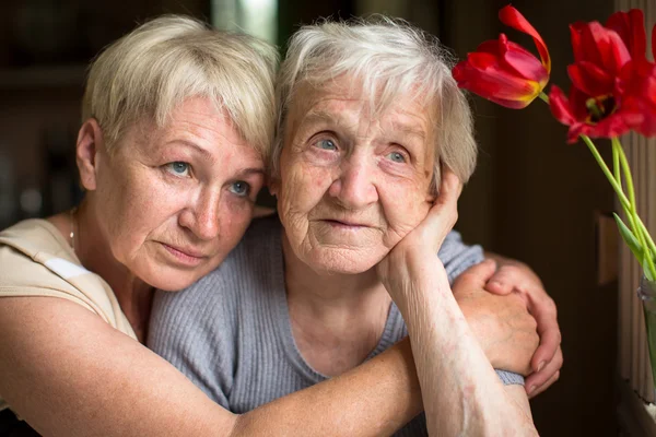 Kvinna i en omfamning med vuxen dotter. — Stockfoto