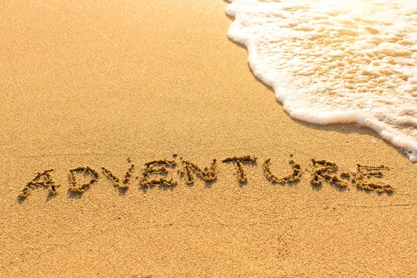 Adventure - inscription on sand beach — Stock Photo, Image