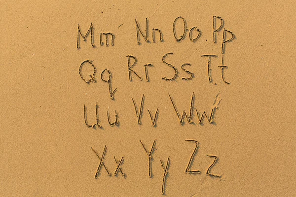 Alfabet letters getekend op het strand — Stockfoto