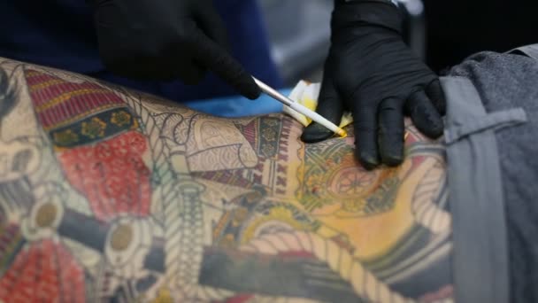 Неизвестный участник фестиваля делает татуировки — стоковое видео