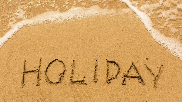 Holiday - inscription on sand beach — Stock Photo, Image