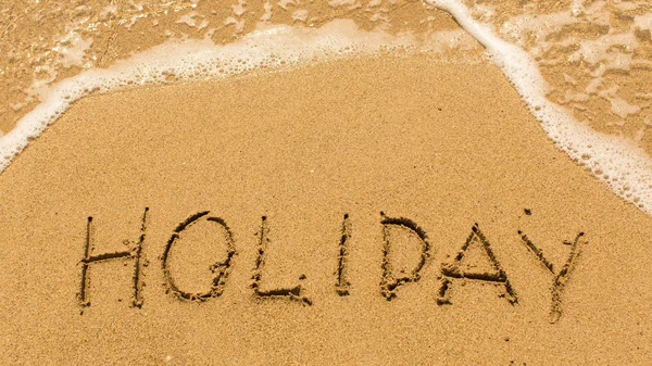 Holiday - inscription on sand beach Stock Picture