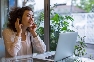 Dizüstü bilgisayar ile kafede oturan kız