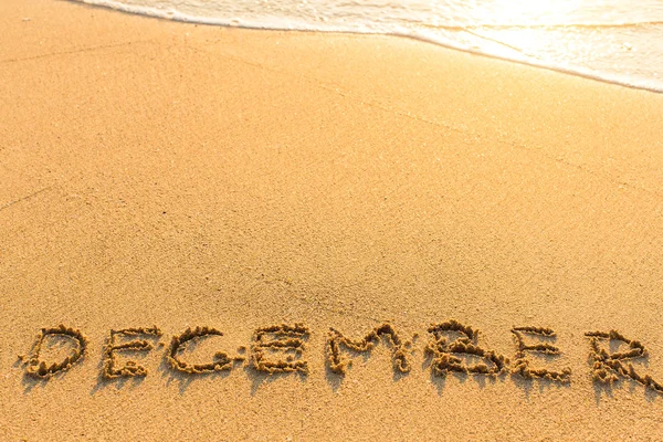 Dezembro - inscrição na praia de areia — Fotografia de Stock
