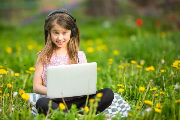 Kleines Mädchen mit Laptop und Kopfhörer — Stockfoto