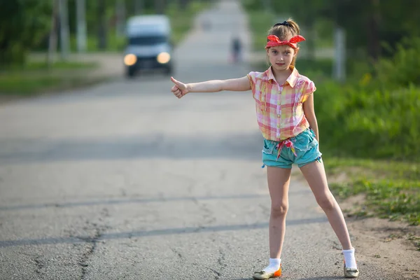 Fata autostopist în picioare pe drum . — Fotografie, imagine de stoc