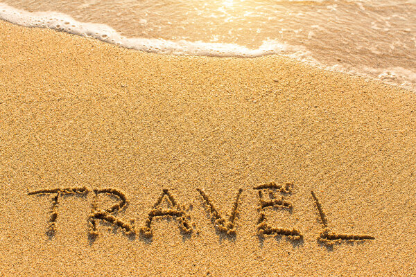 Travel - drawn by hand on a sandy golden sea beach.