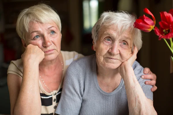 Eftertänksamt äldre kvinna med dotter — Stockfoto