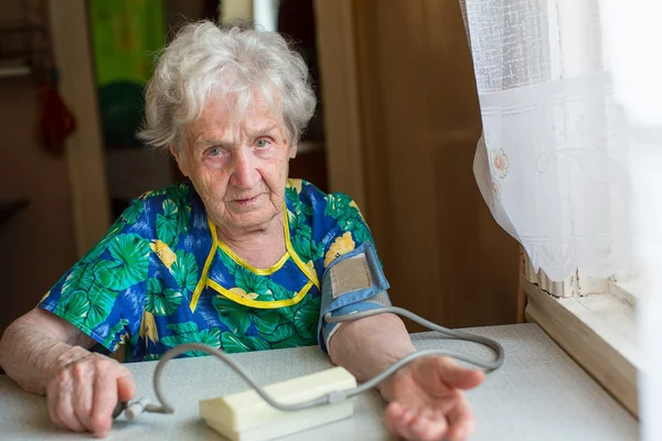 Frau misst sich Blutdruck. — Stockfoto