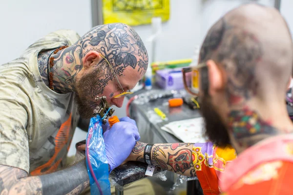 Kimliği belirsiz Festivali katılımcı bir dövme yapmak — Stok fotoğraf