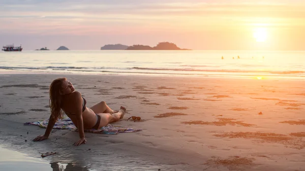 Junge Frau liegt am Strand — Stockfoto