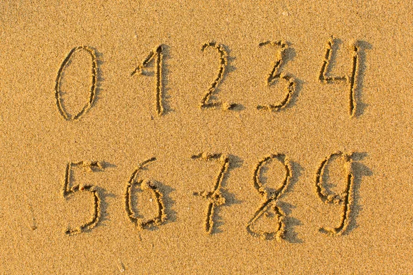 Números dibujados a mano sobre arena — Foto de Stock