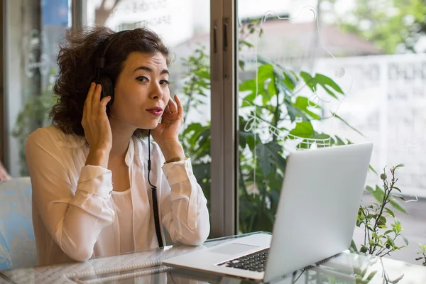 Mujer asiática en auriculares con portátil —  Fotos de Stock