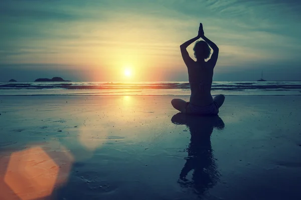 Silhouette of woman practicing yoga Stock Photo