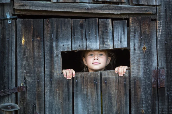 Niña mirando desde la ventana — Foto de Stock