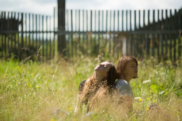 Twee meisjes zitten in clearing — Stockfoto