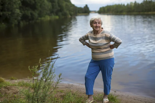 Пожилая женщина на берегу озера — стоковое фото