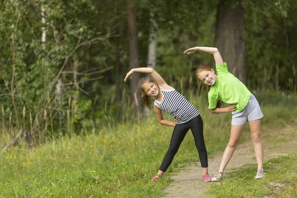 Små söta flickor uppvärmning utomhus — Stockfoto