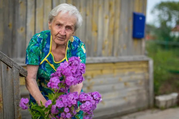 Vrouw zorgt voor bloemen — Stockfoto