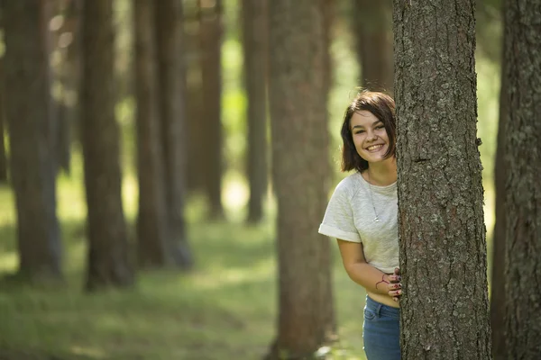 Tienermeisje staat op een boom — Stockfoto