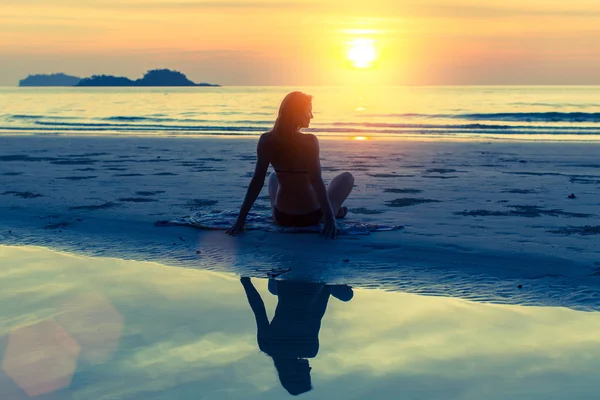 Schönes Mädchen sitzt am Strand — Stockfoto