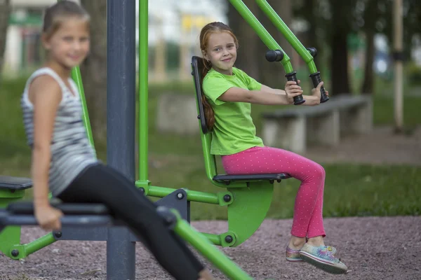 Meisjes zitten op fitnessapparatuur — Stockfoto