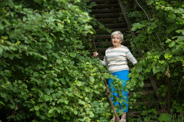 Ältere Frau steht im Park — Stockfoto