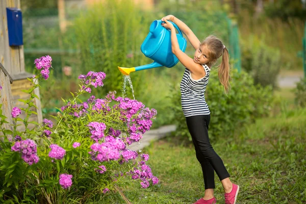 Meisje water geven bloemen — Stockfoto