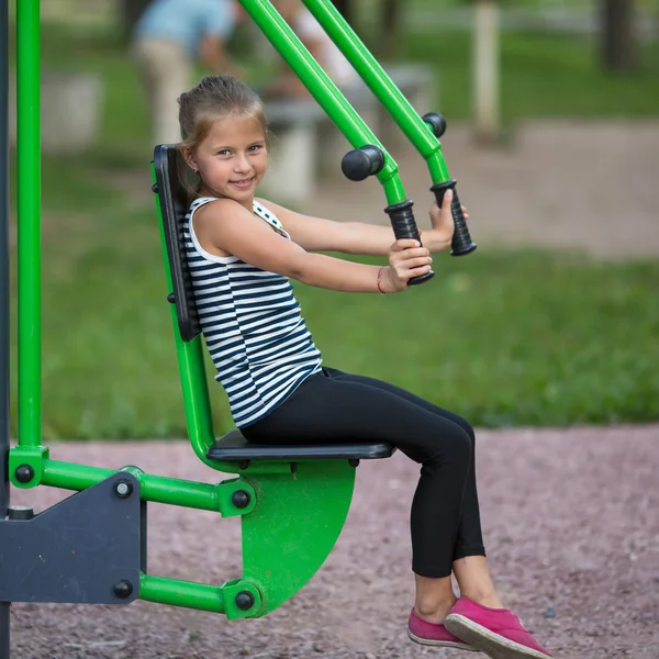 Petite fille est engagée dans l'équipement sportif — Photo