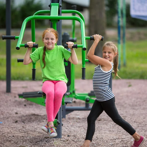 Pequenas meninas está envolvida em equipamentos esportivos — Fotografia de Stock