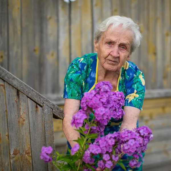 Starší žena péče o květiny — Stock fotografie