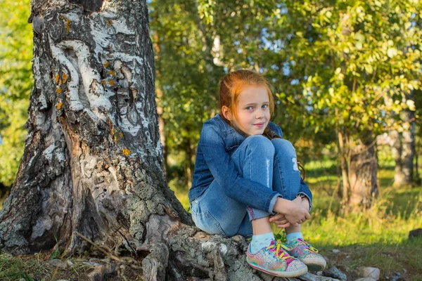 Flicka sitter på rötter — Stockfoto