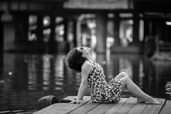 Asiatische Frau sitzt auf Pier — Stockfoto