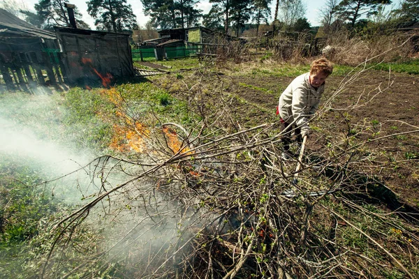 Seorang Wanita Tua Membersihkan Dan Membakar Cabang Cabang Peternakannya — Stok Foto