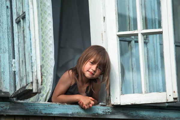 Klein Schattig Meisje Kijkt Uit Het Raam Huis Het Dorp — Stockfoto