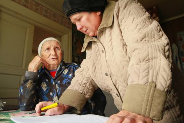OZERA, RUSSIA - SEP 23, 2011: Uluslararası Yaşlılar Günü Faaliyetleri sırasında (1 Ekim), emekliler ve engelliler için çalışan sosyal hizmetler merkezi, yaşlı bir kadından emir alır.