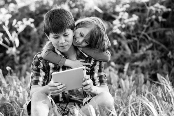 Niño Con Hermana Menor Sentado Aire Libre Uso Tableta Foto —  Fotos de Stock