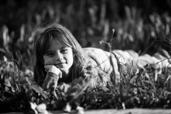 小女孩躺在公园的草地上 黑白照片 — 图库照片