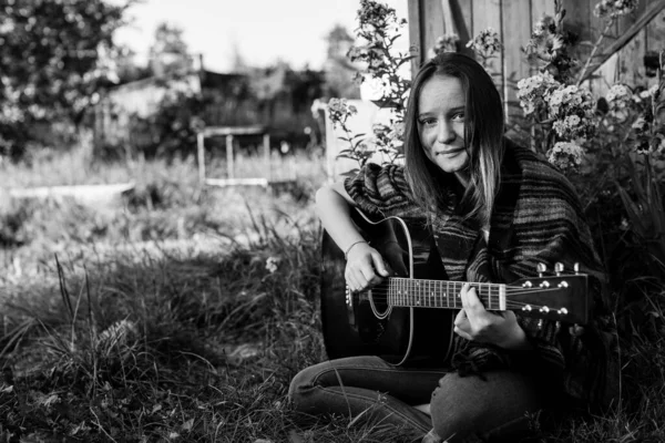 Młoda Dziewczyna Gra Gitarze Akustycznej Siedząc Zewnątrz Czarno Białe Fotografie — Zdjęcie stockowe