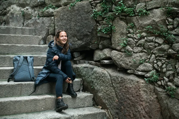 若い女性は旧市街の古代の石の階段の階段に座っています — ストック写真