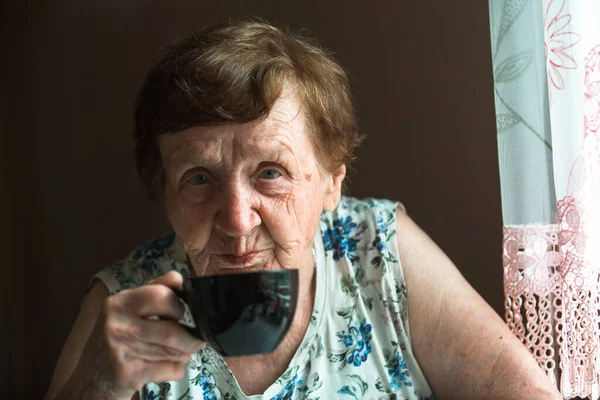 一位老年妇女在家喝咖啡的肖像 — 图库照片
