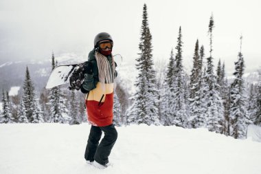 Karlı bir yamaçta kar kaykayı yapan kadın..