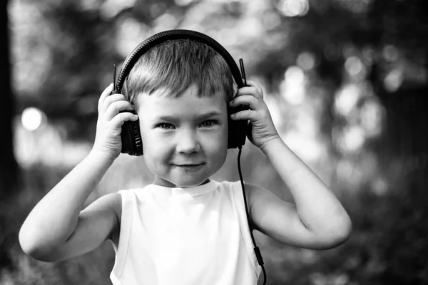 小男孩在户外用耳机欣赏音乐 黑白照片 — 图库照片