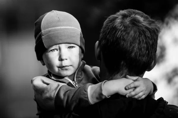一个小男孩坐在他父亲的怀里 黑白照片 — 图库照片