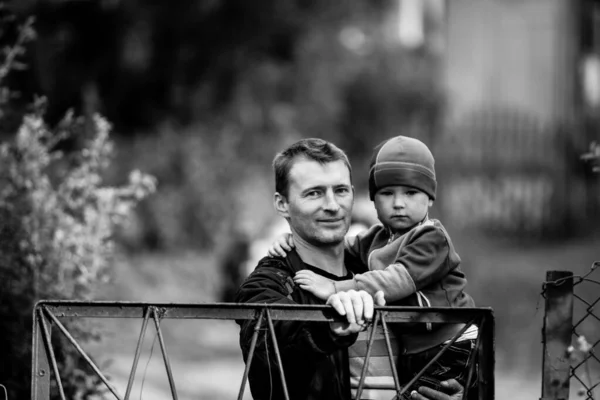 男人把他的小儿子抱在怀里 在村子里 黑白照片 — 图库照片